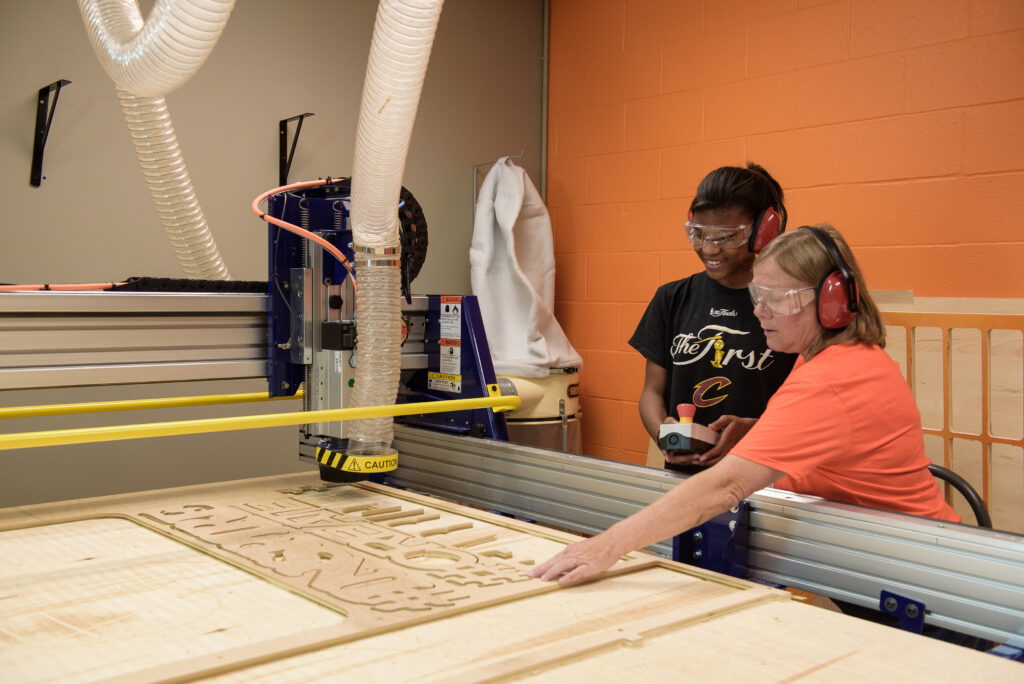 Two women using laser cutter