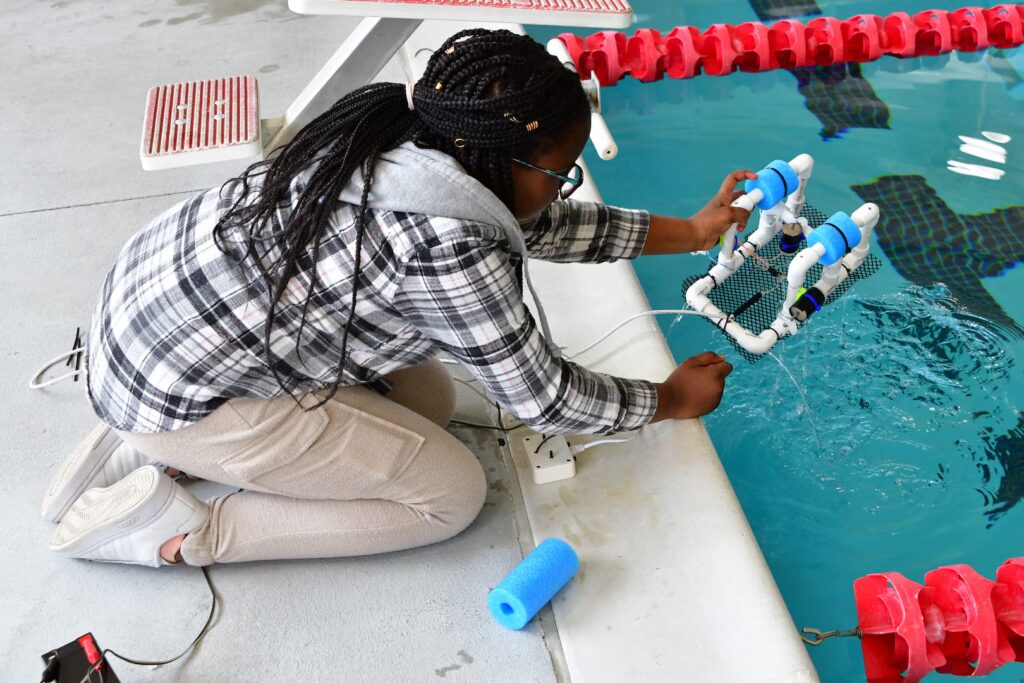 girl testing SeaPerch robot at naval center