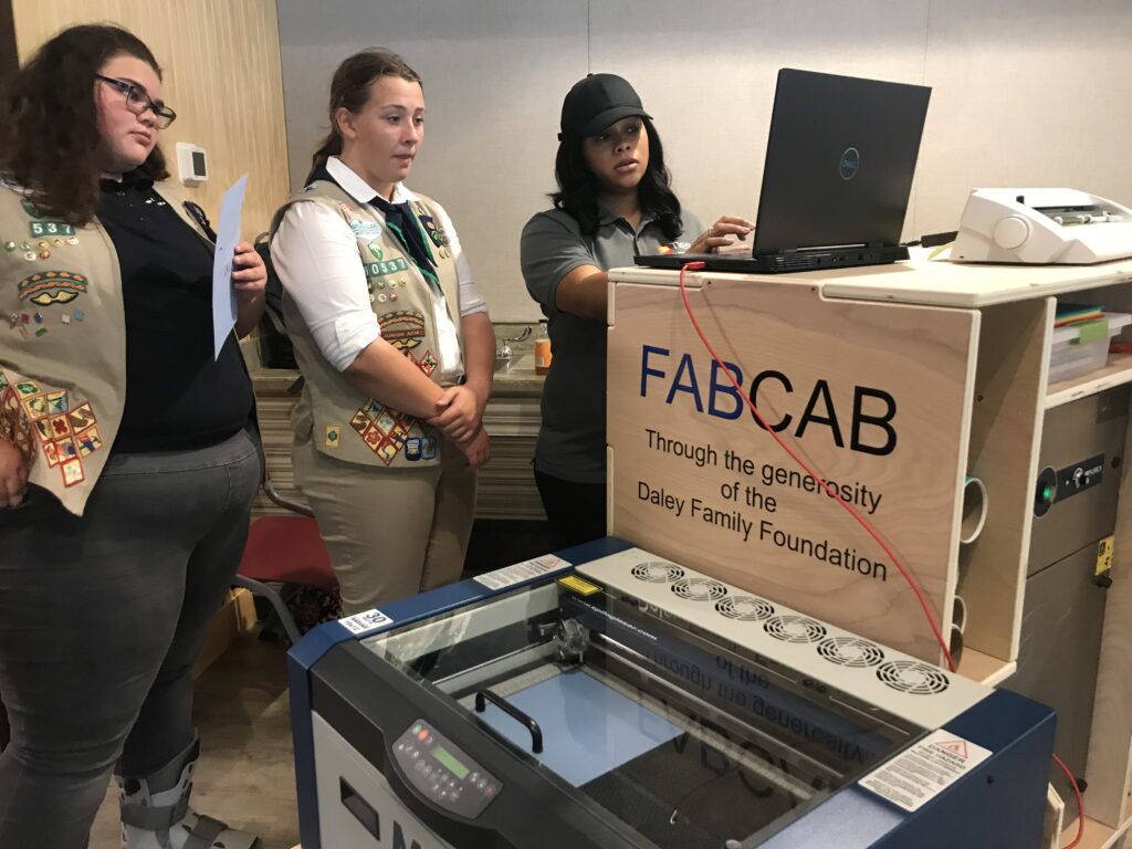 TIES staff, Andrea Fields teaching the girls about the Laser Cutter at Girl Scoult Council of Northeast Ohio